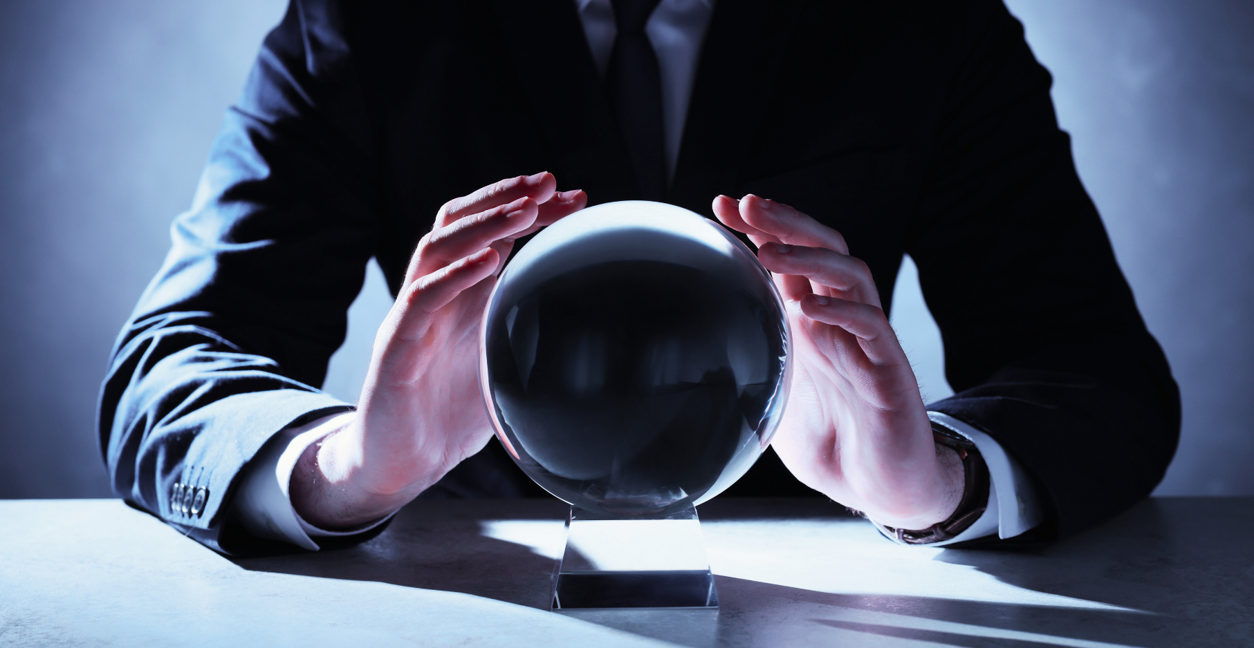 man in suit trying to predict the future with crystal ball